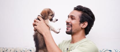 A man hugs his puppy