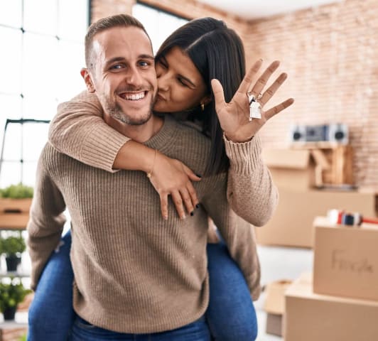 Couple kissing while holding house keys