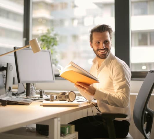 Business man sitting and smiling at a desk