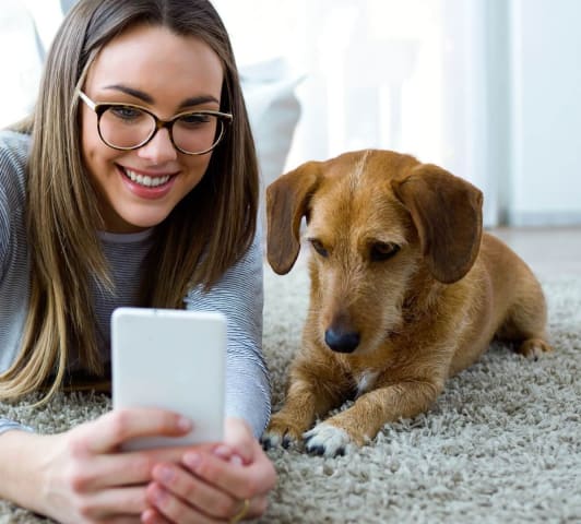 woman sitting on the floor with her dog taking a picture