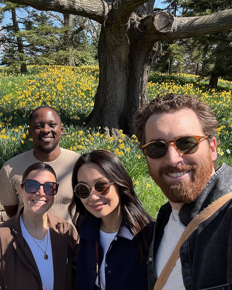 Seed team members smiling together in a park full of yellow flowers
