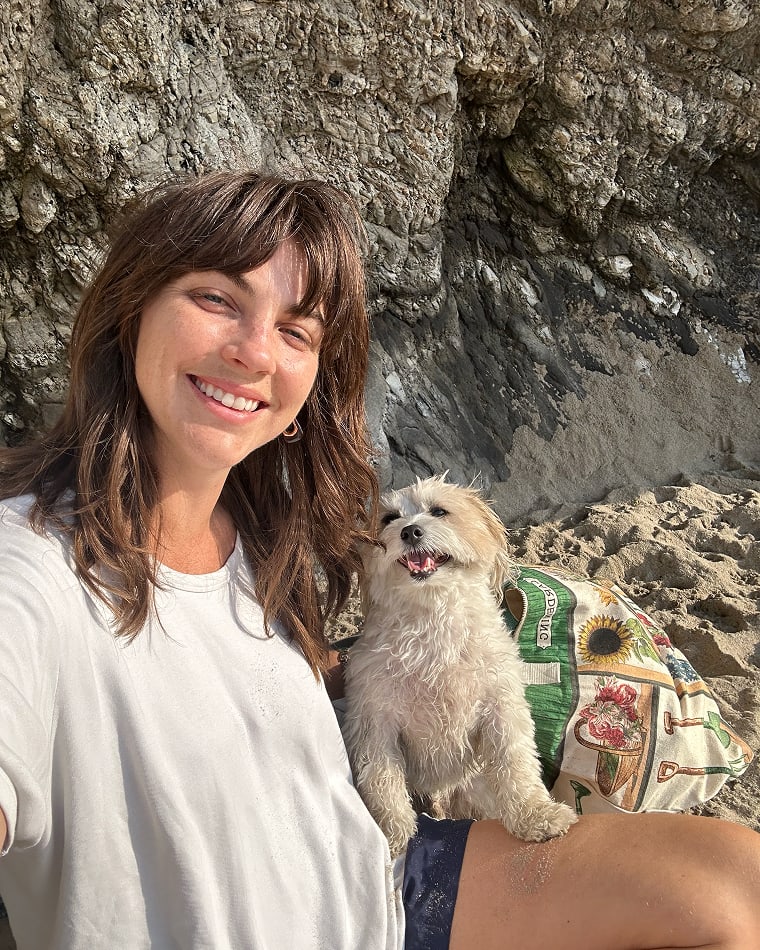 A Seed team member with a dog at the beach