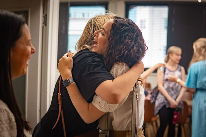 Avital embracing a member at a HiFam meetup