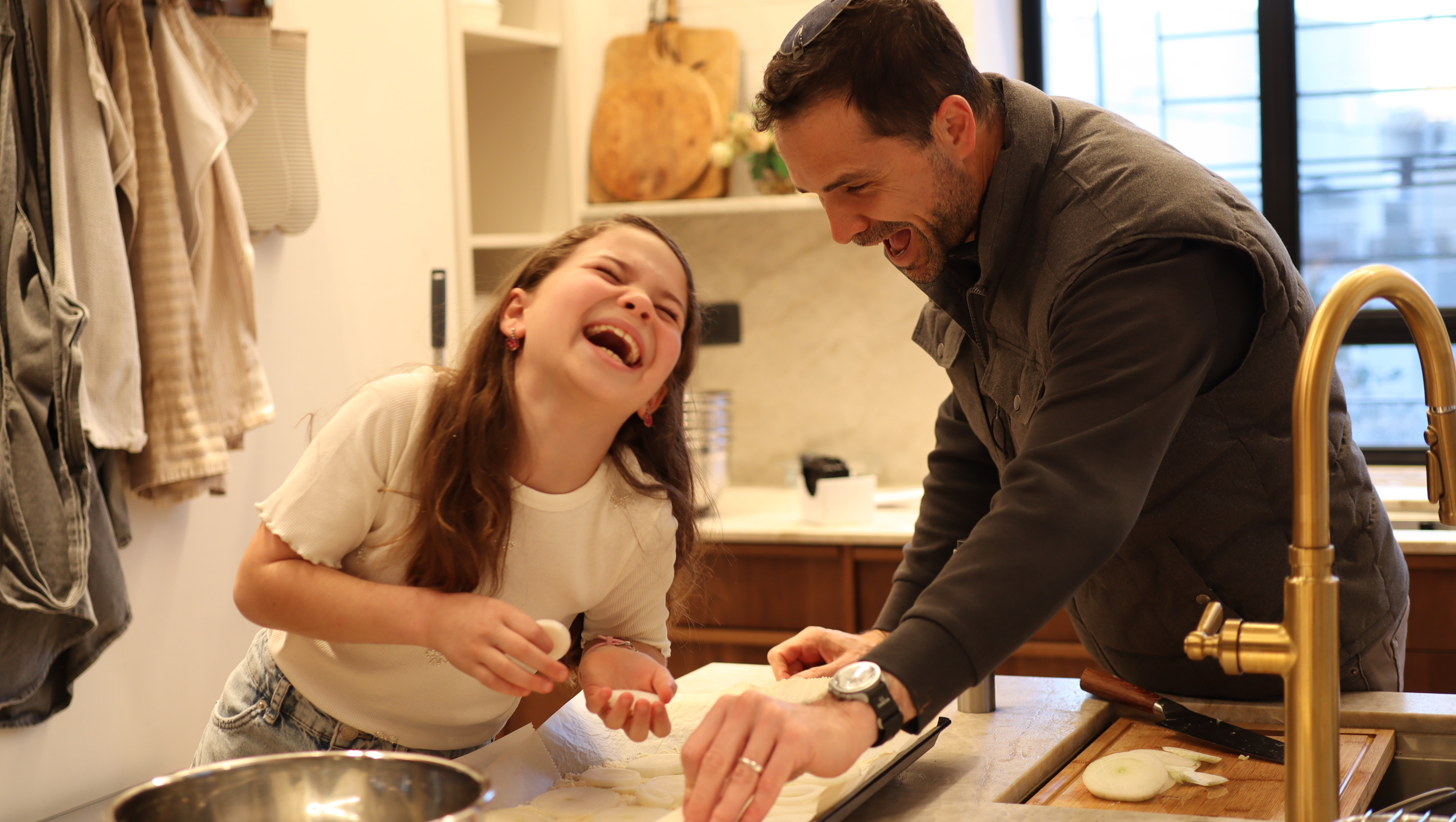 Dad and daughter laughing together in the kitchen