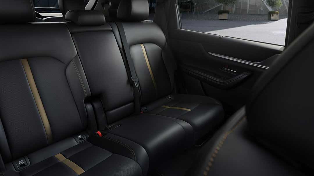 Looking back at the 2nd row seats, finished in black leather, of a Mazda CX-80 7-seat hybrid SUV