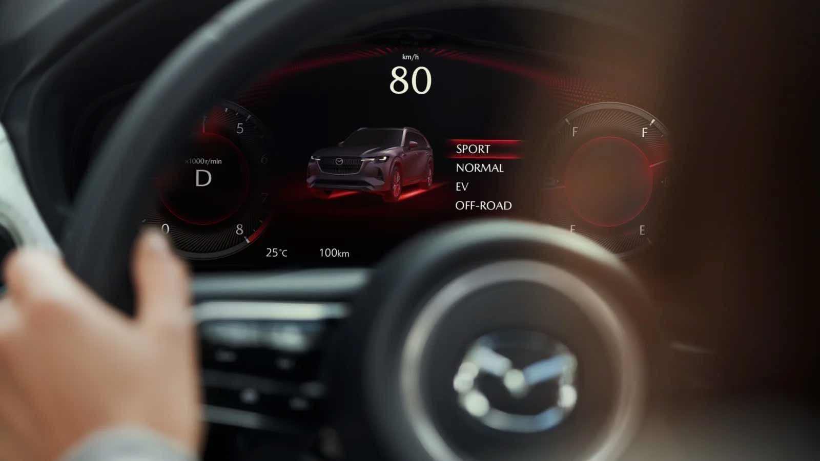 Close-up of the digital instrument panel viewed through the steering wheel on a Mazda CX-80 7-seat hybrid SUV