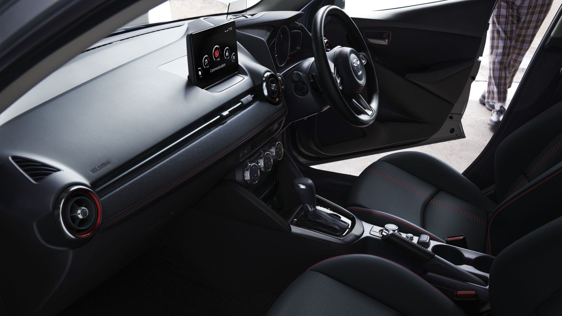 Interior view of the black dashboard of a Mazda2 hatch