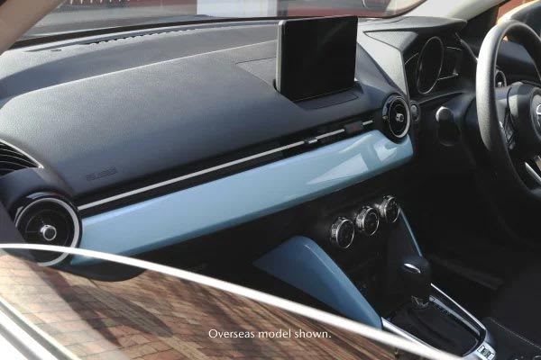 Looking inside the front passenger window at the Mazda2 hatch's dashboard