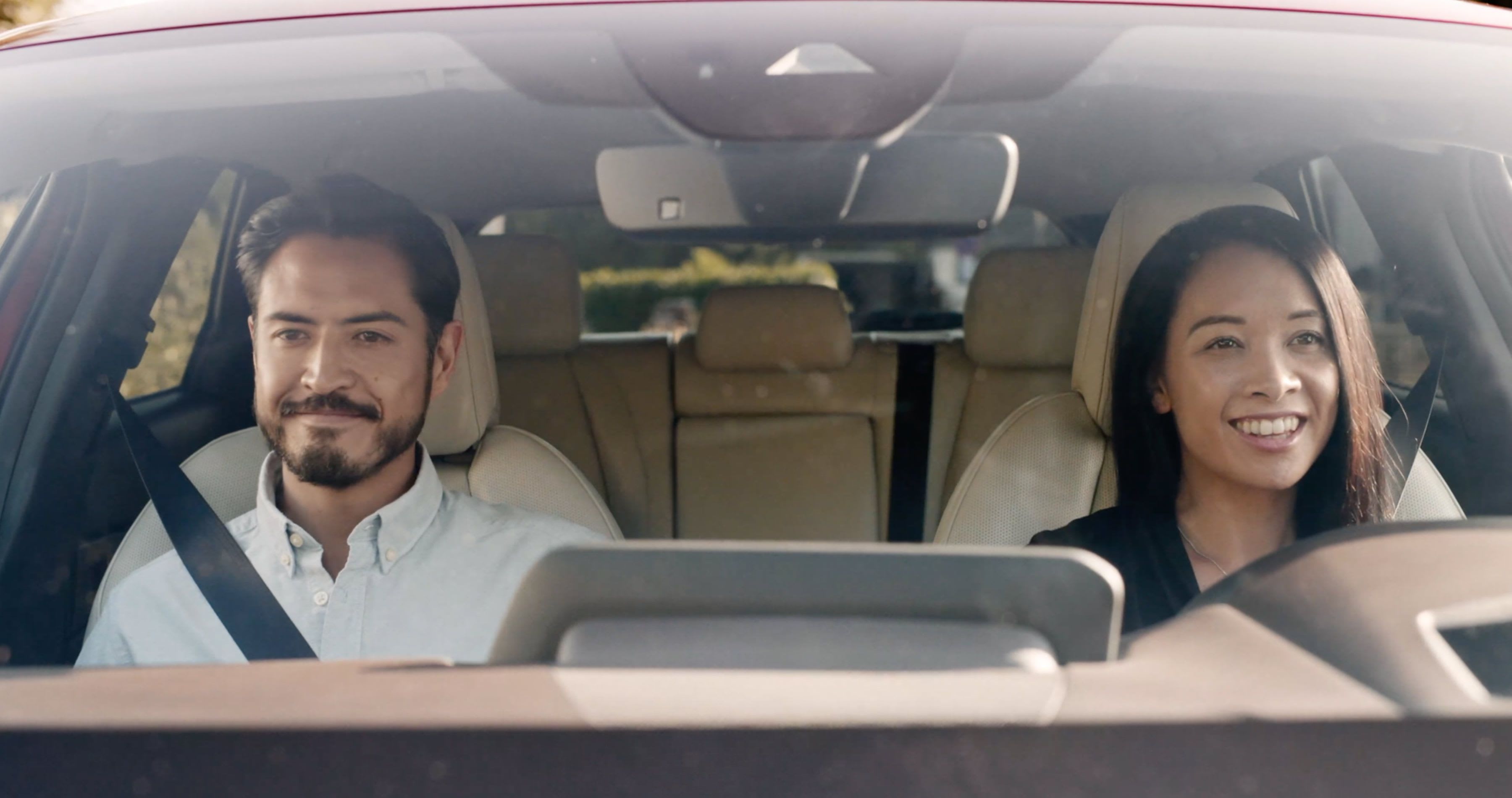 Looking through the windscreen of a woman driving her Mazda car with a male passenger