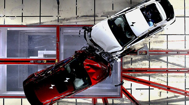 Official crash test image shown from above showing a red and white car in an offset frontal collision