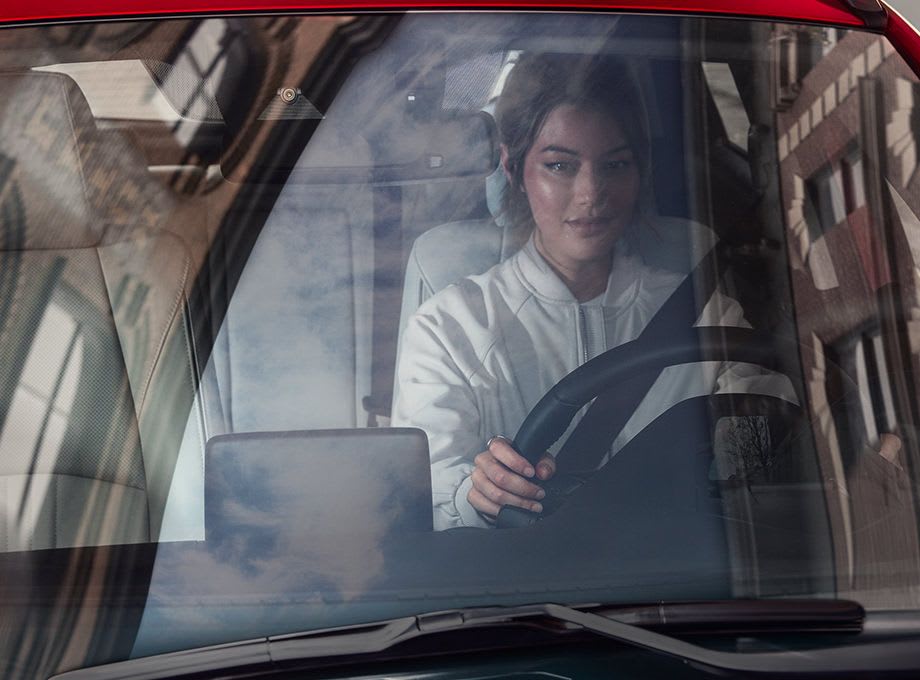 Looking through the windscreen of a woman driving her Mazda