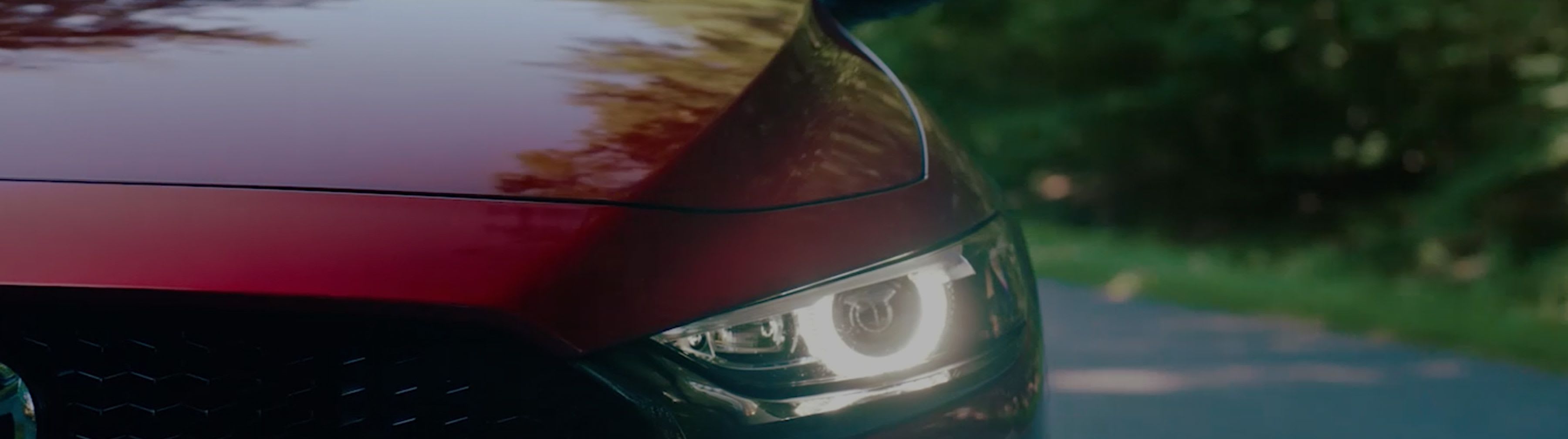 Close-up of a headlight on a red Mazda