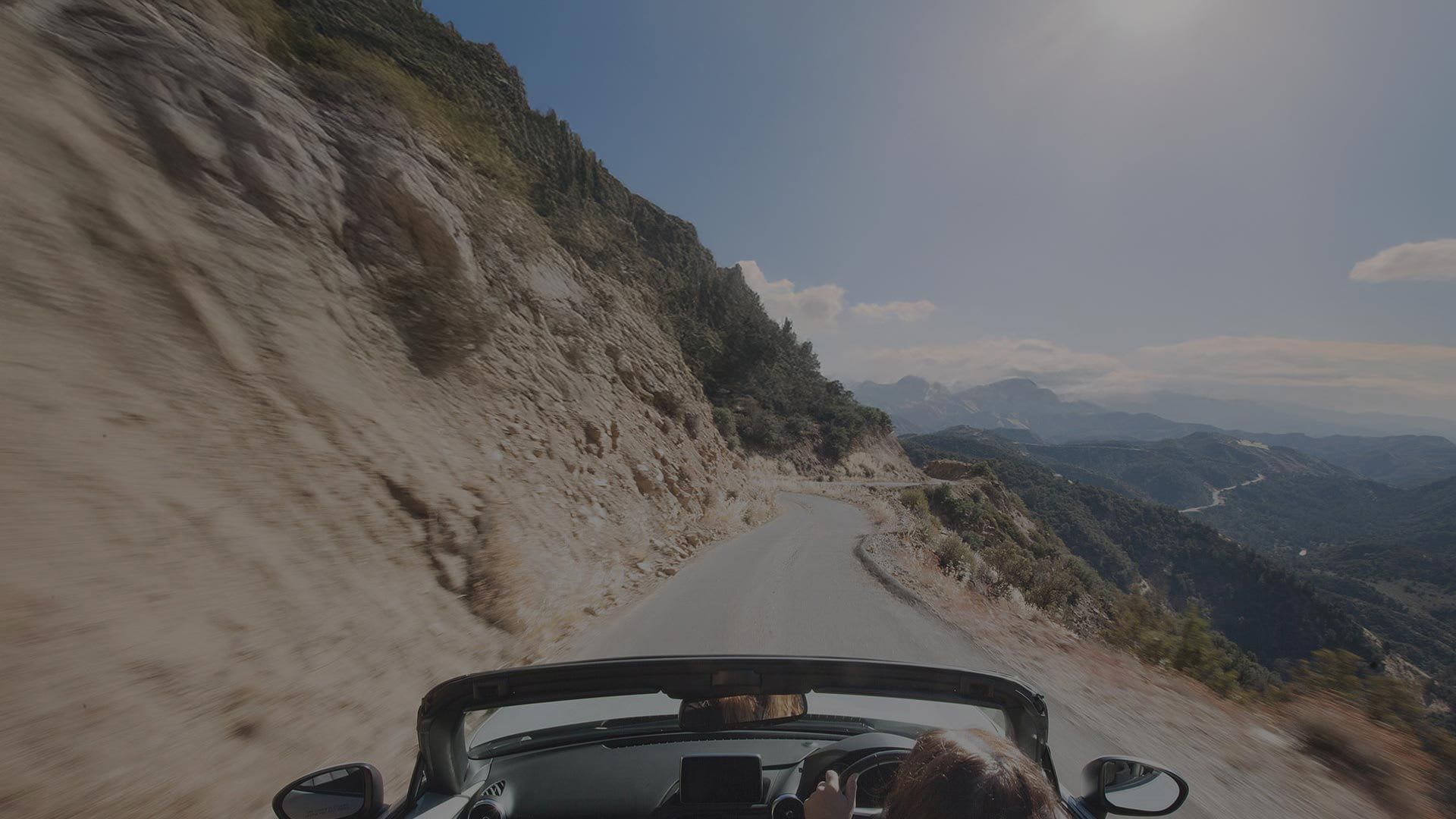 View of the top of a Mazda MX-5 Roadster driving on a mountain road