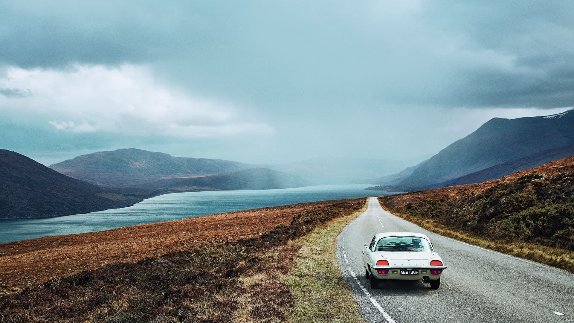 Classic Mazda Cosmo sports car driving on an open road