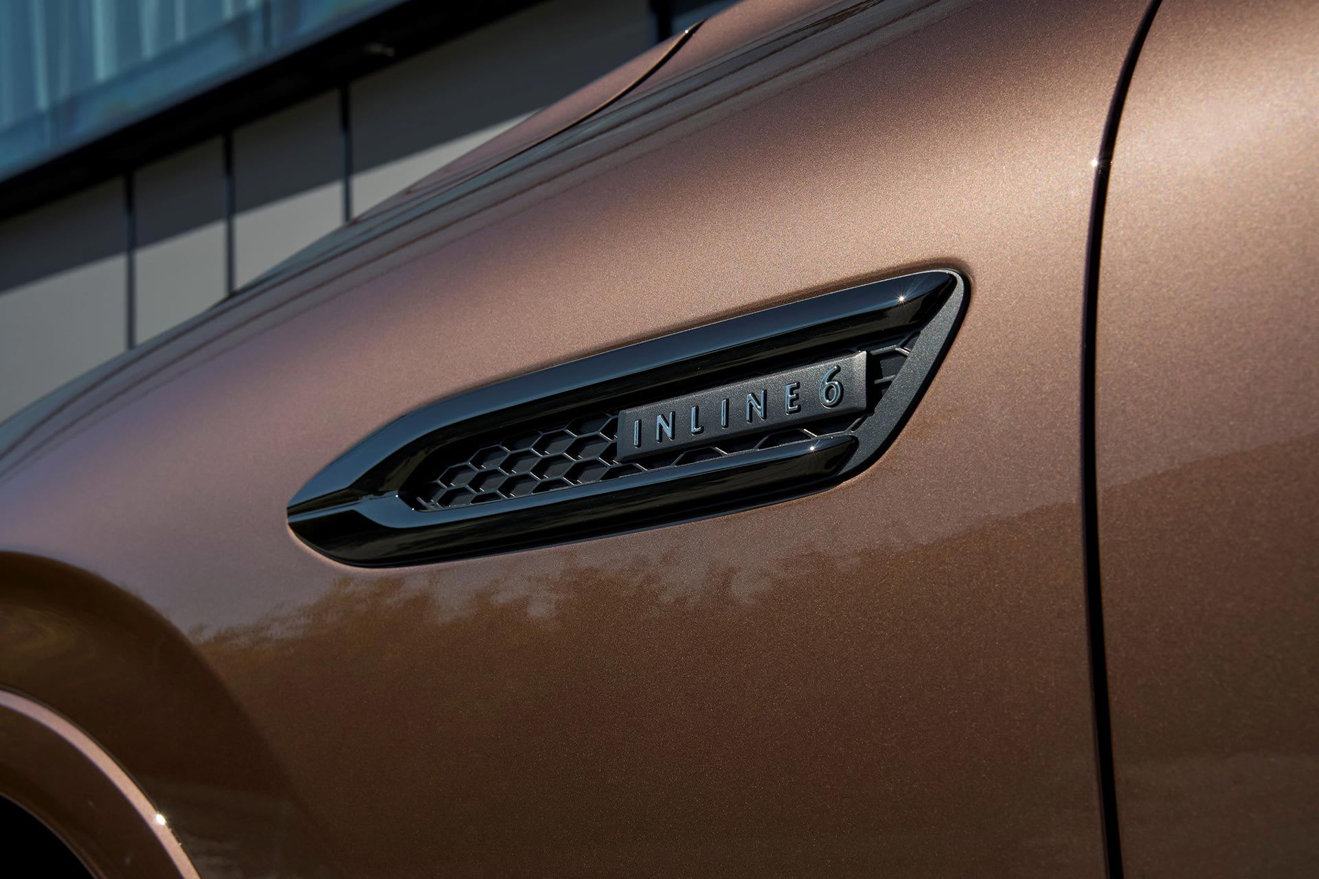 Close up of the side grille with 'inline 6' badging on a Melting Copper Mazda CX-80 Homura Hybrid SUV