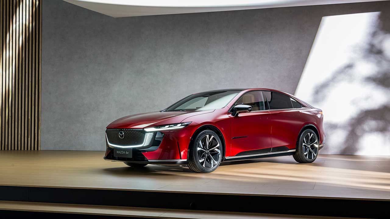 Front three quarter view of a red Mazda6E electric car on display 
