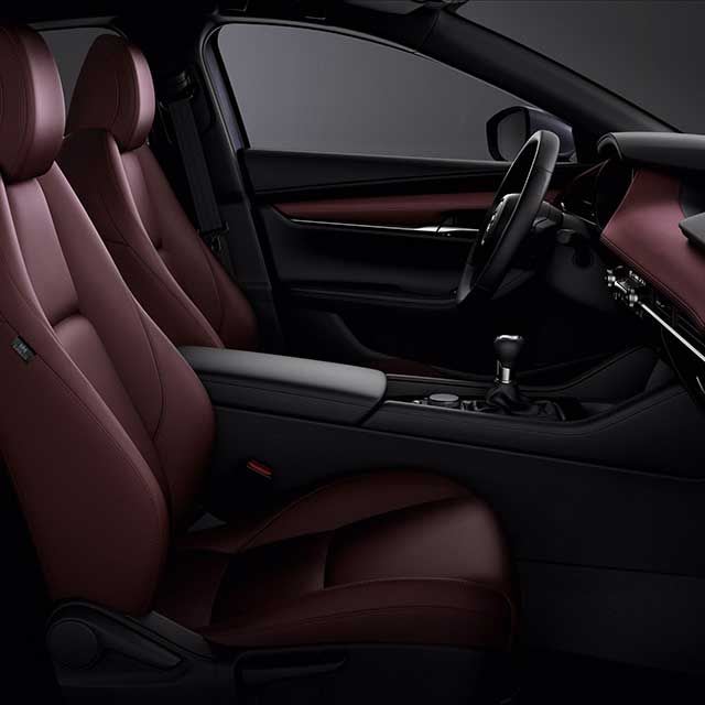 Interior of the Mazda3 hatchback with red leather seats and dashboard 