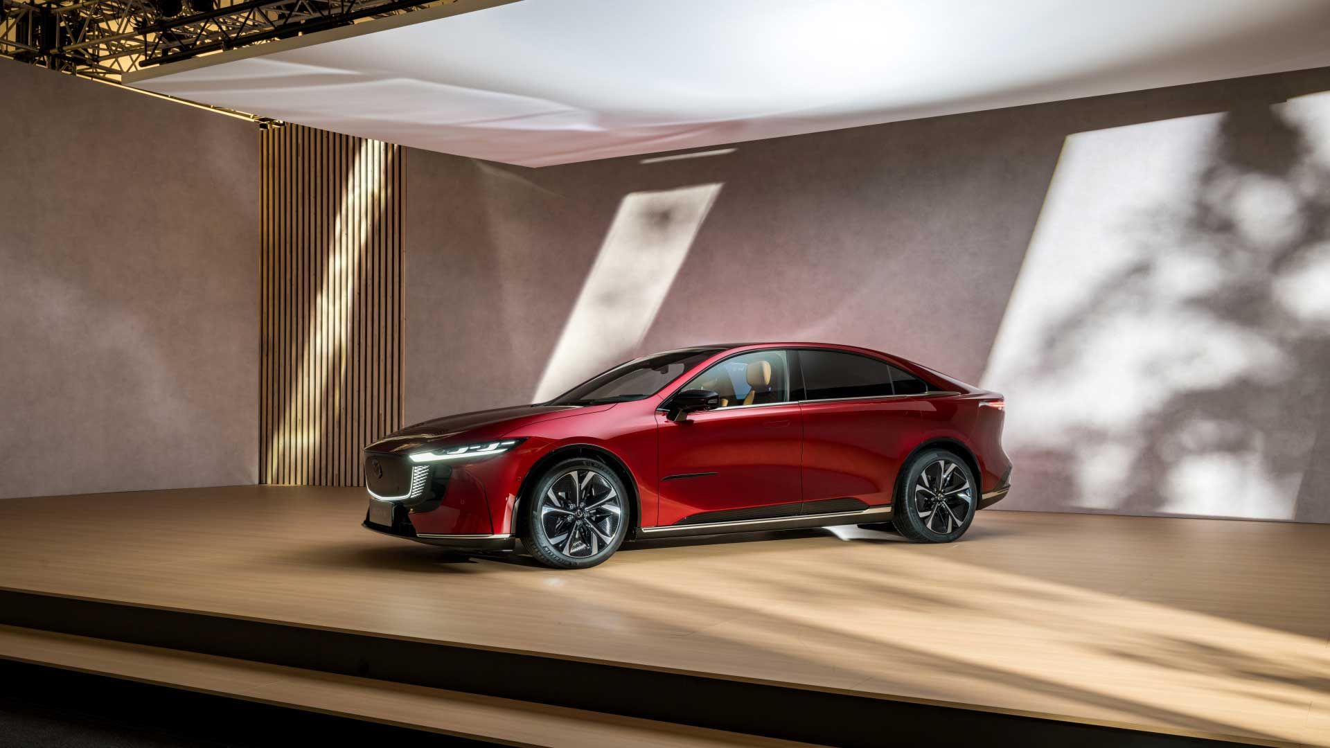 Front three quarter view of a red Mazda6E electric car on display