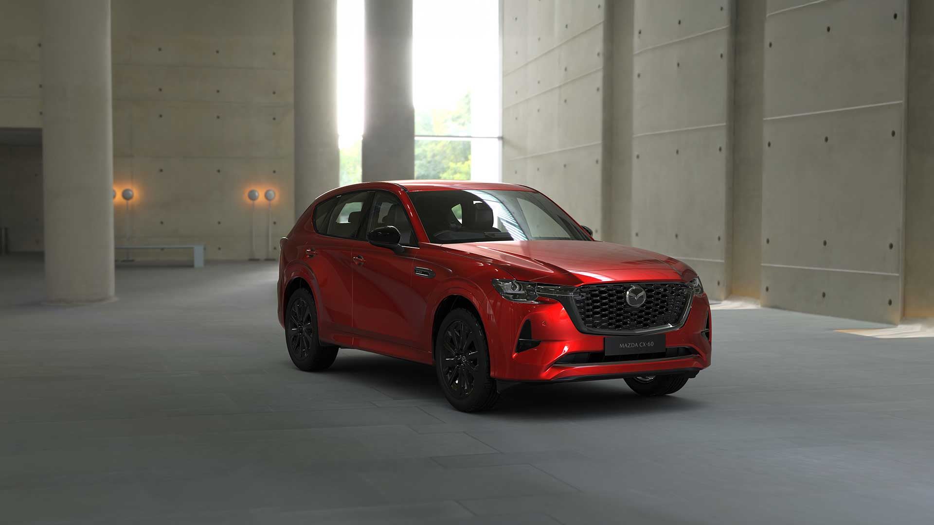 Front three quarter view of a Soul Red Mazda CX-60 SUV SP Hybrid parked in a gallery