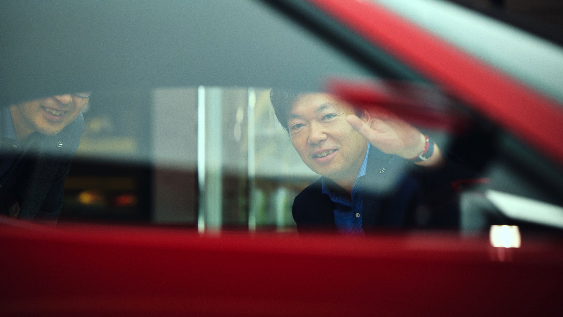 Looking through the side windows of a red Mazda Iconic SP concept car of a Mazda Executive looking inside the car
