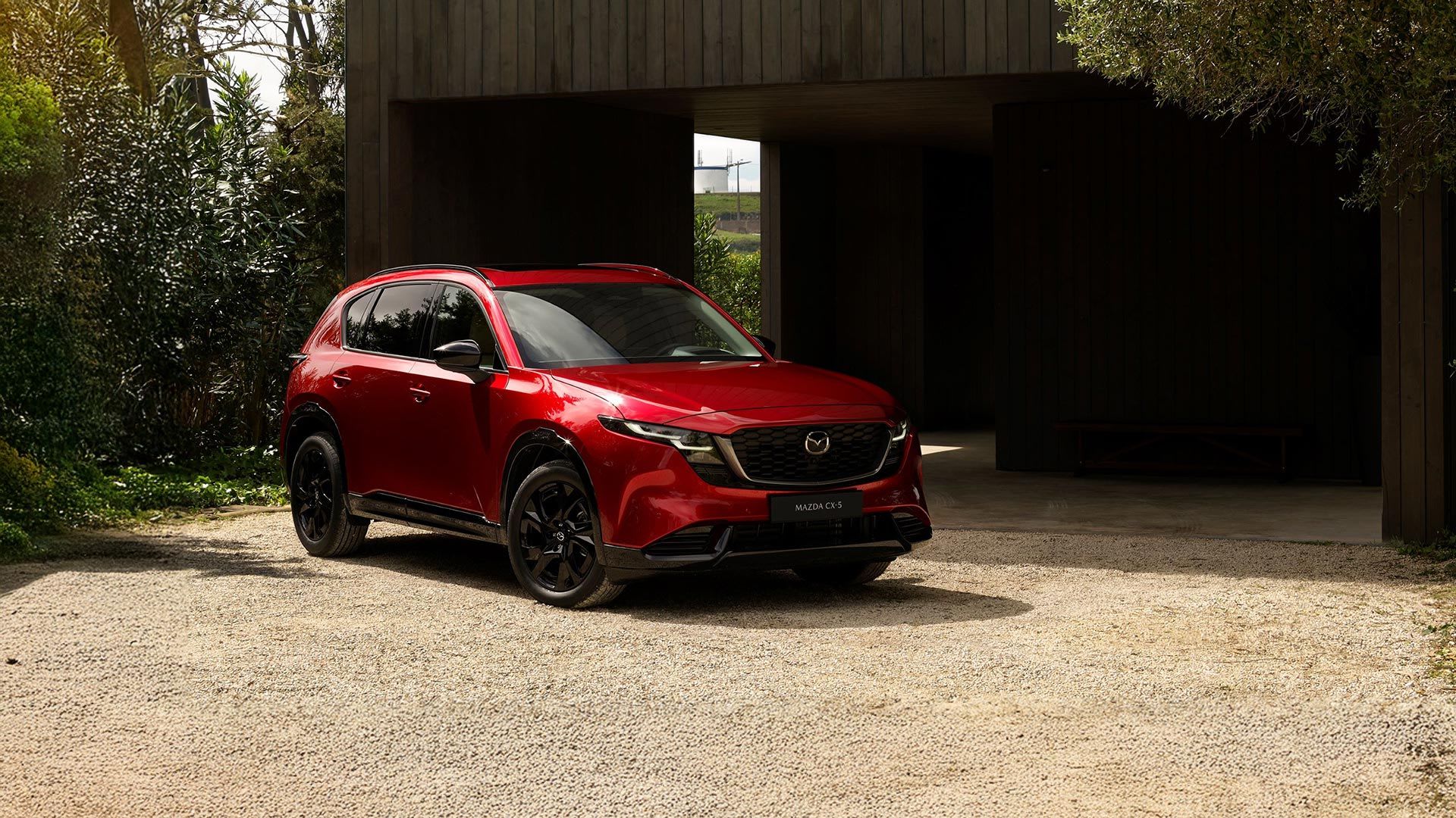 Front three quarter view of a red all-new Mazda CX-5 SUV parked on a driveway