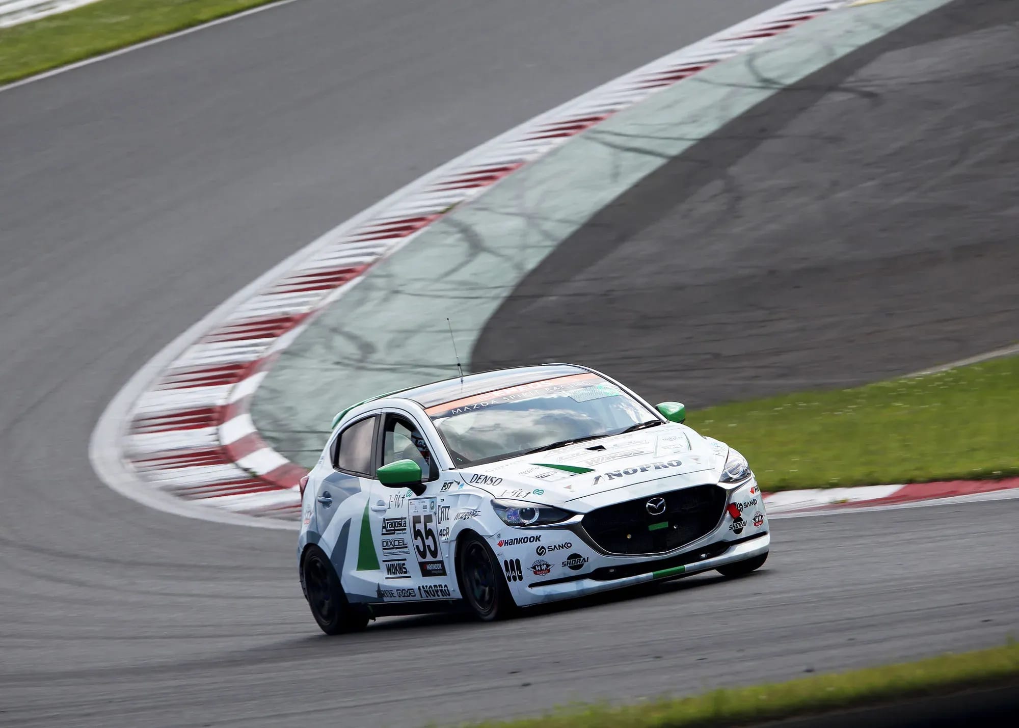 White Mazda2 biofuel race car driving on a race track