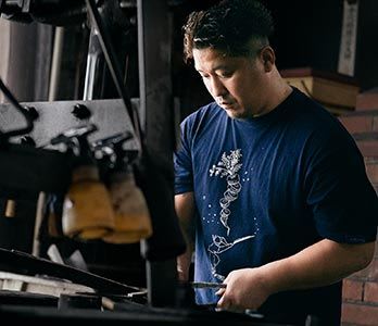 Japanese artisan knife-maker working in his workshop