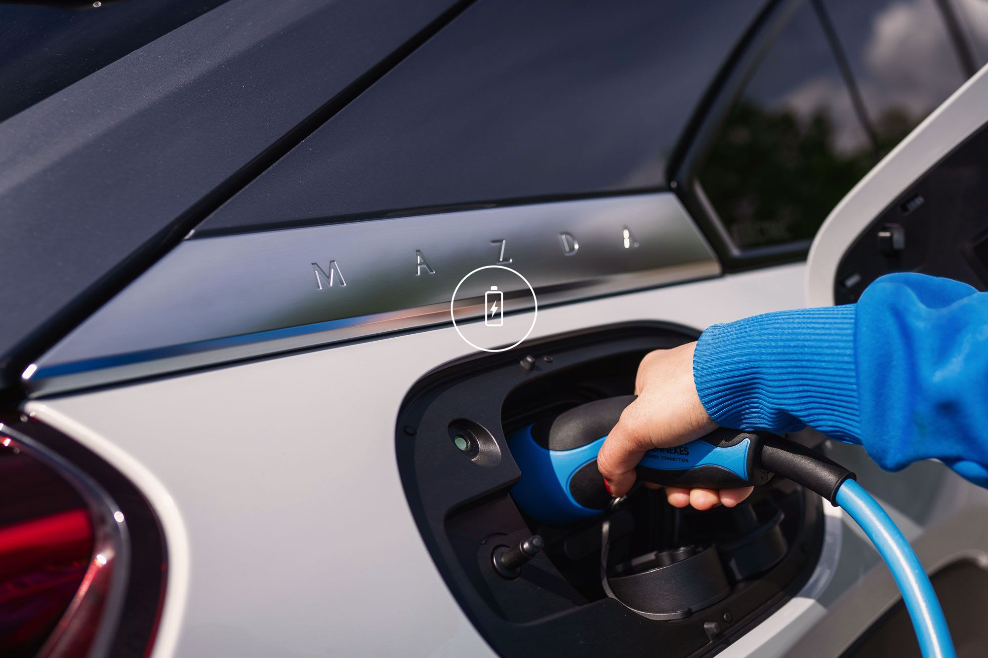 Close up of a silver Mazda electric car being charged