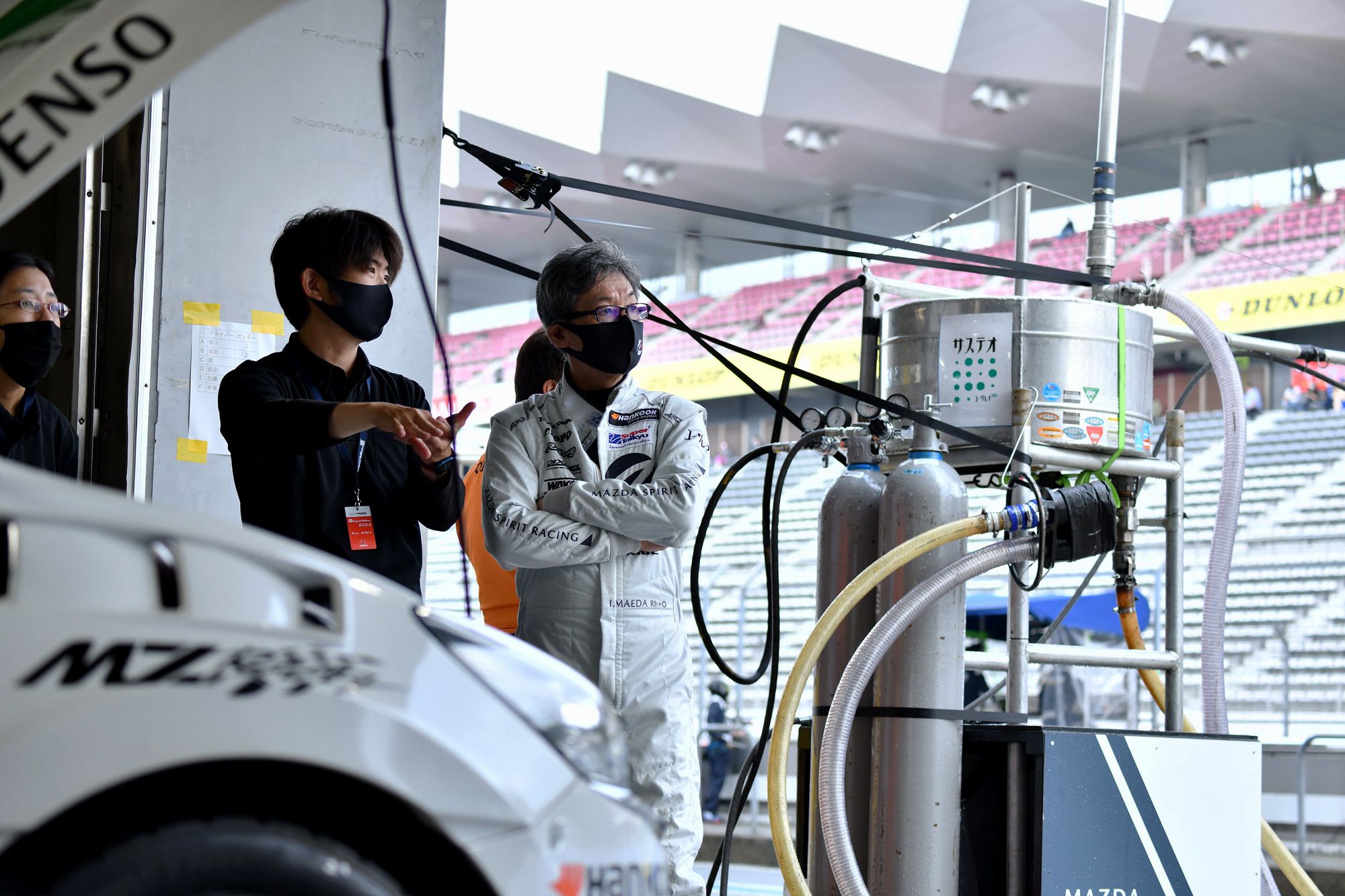 Mazda2 Bio and pit crew inside the garage at a race track