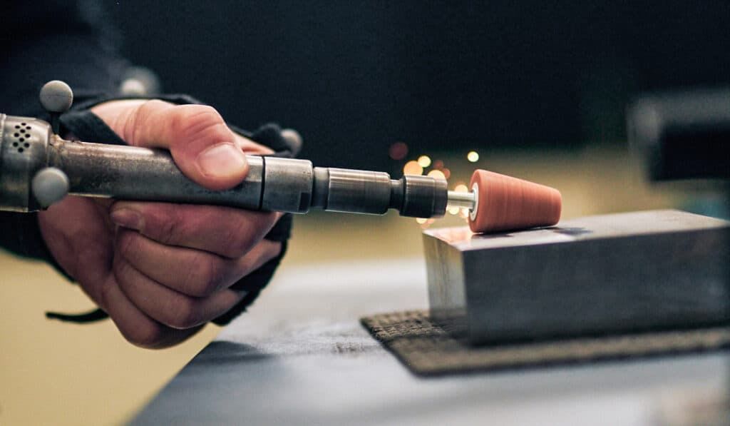 Close up of a Mazda technician operating a precision brush tool