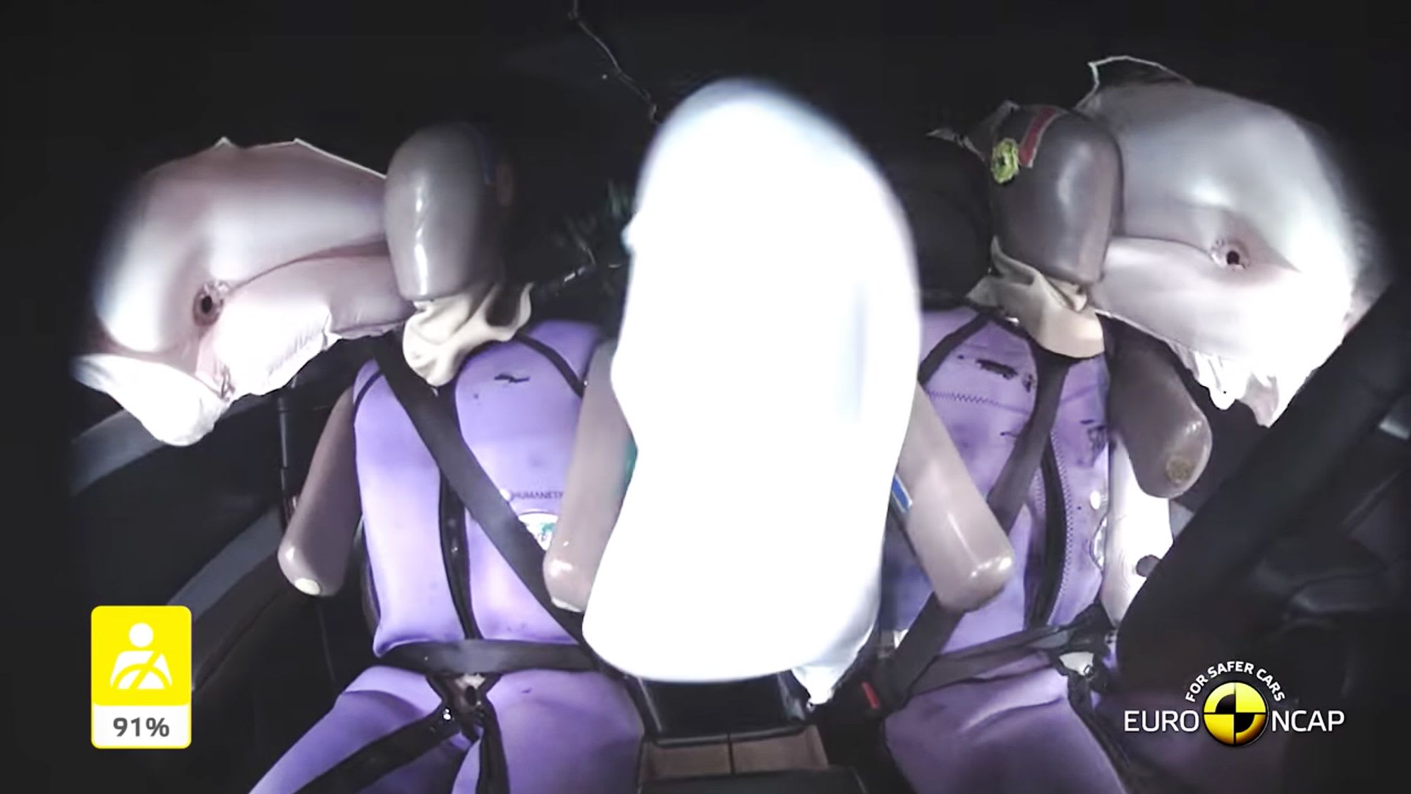 Looking back at crash test dummies in a Mazda car with the airbags deployed