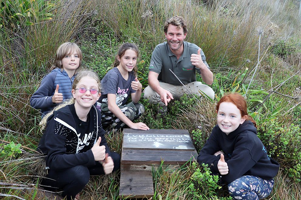Riley Elliott and students from Wainui Beach School with a little blue penguin house