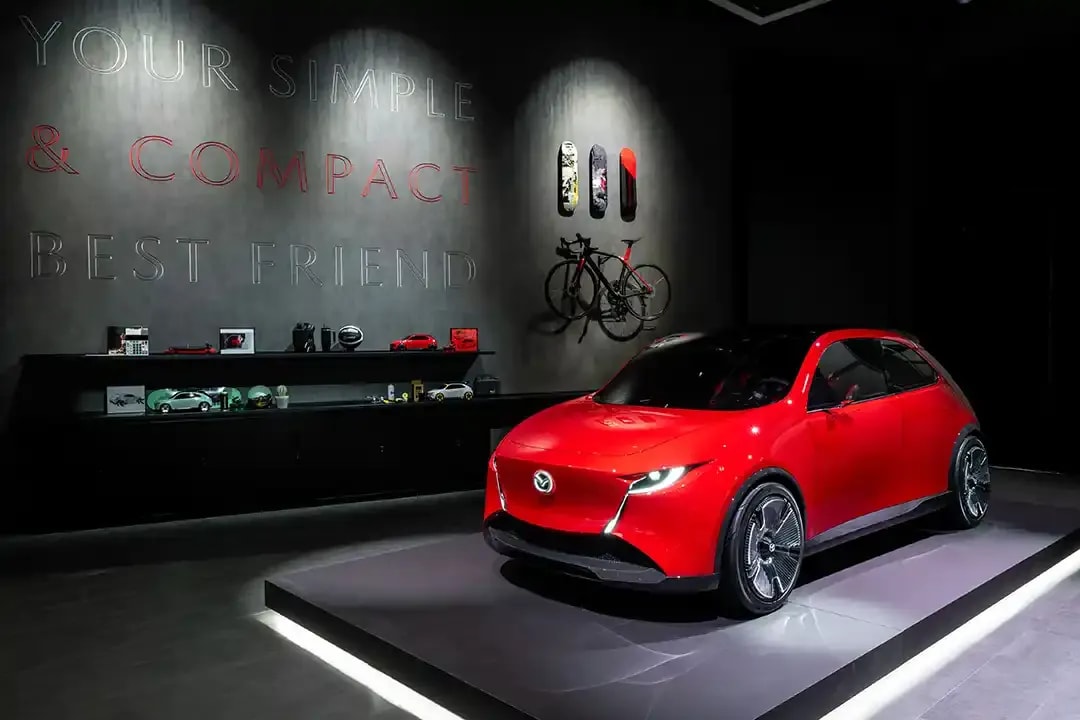 Front three quarter view of a red Mazda Vision X-Compact concept car on the stand at the Japan Mobility Show 2025