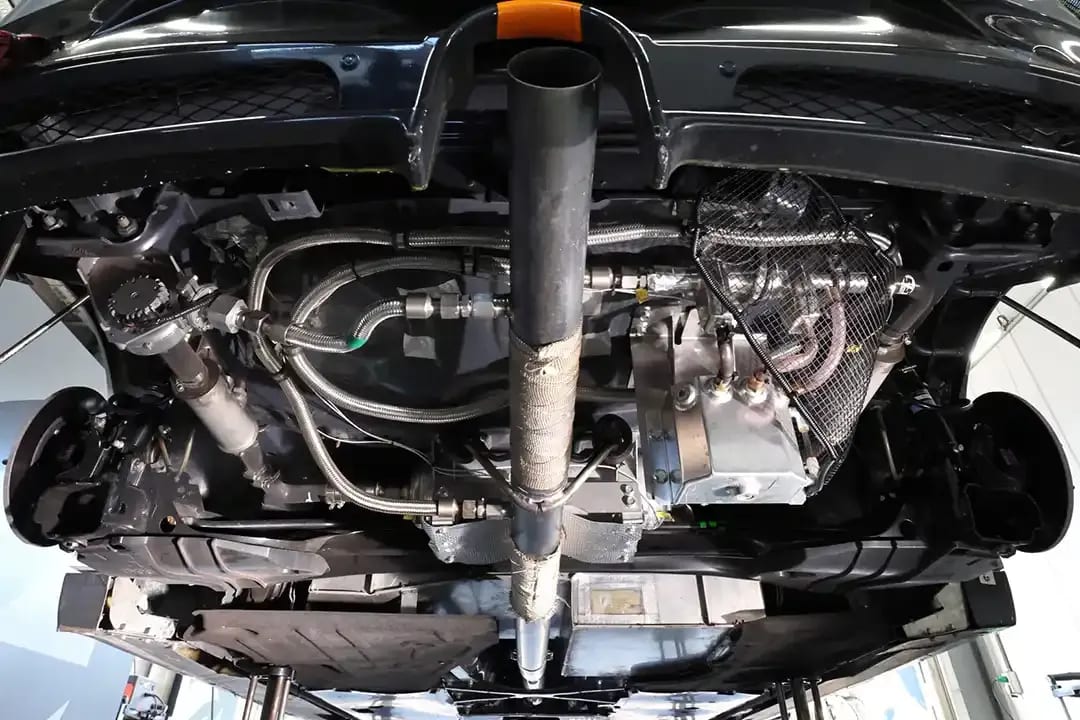 Underbody of a Mazda3 race car showing the engine, exhaust and experimental carbon capture system