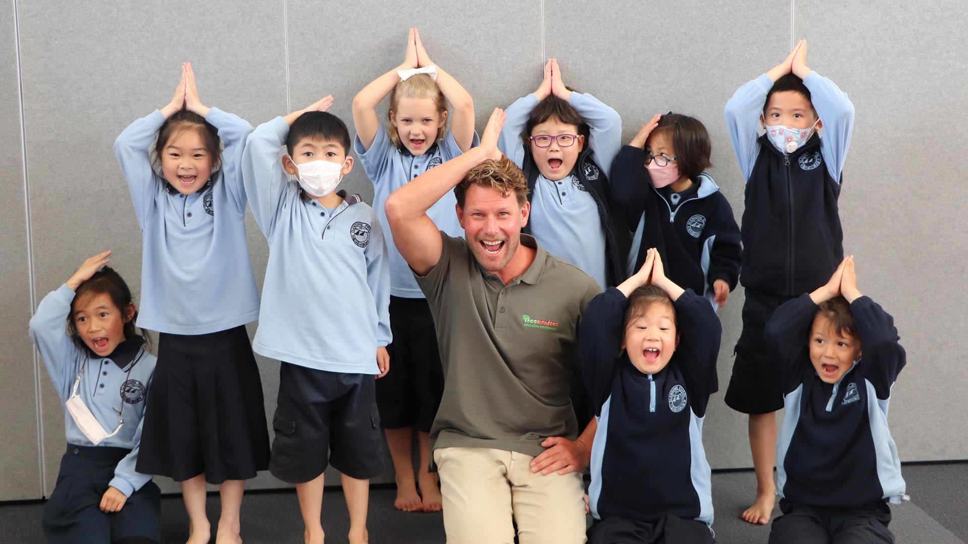 Children from Glendowie School in Auckland and shark scientist Dr Riley Elliott pose for a photograph