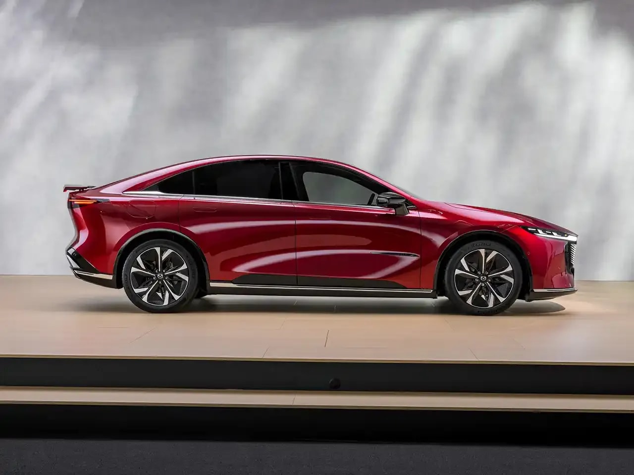 Side view of a fully electric red Mazda 6e on display