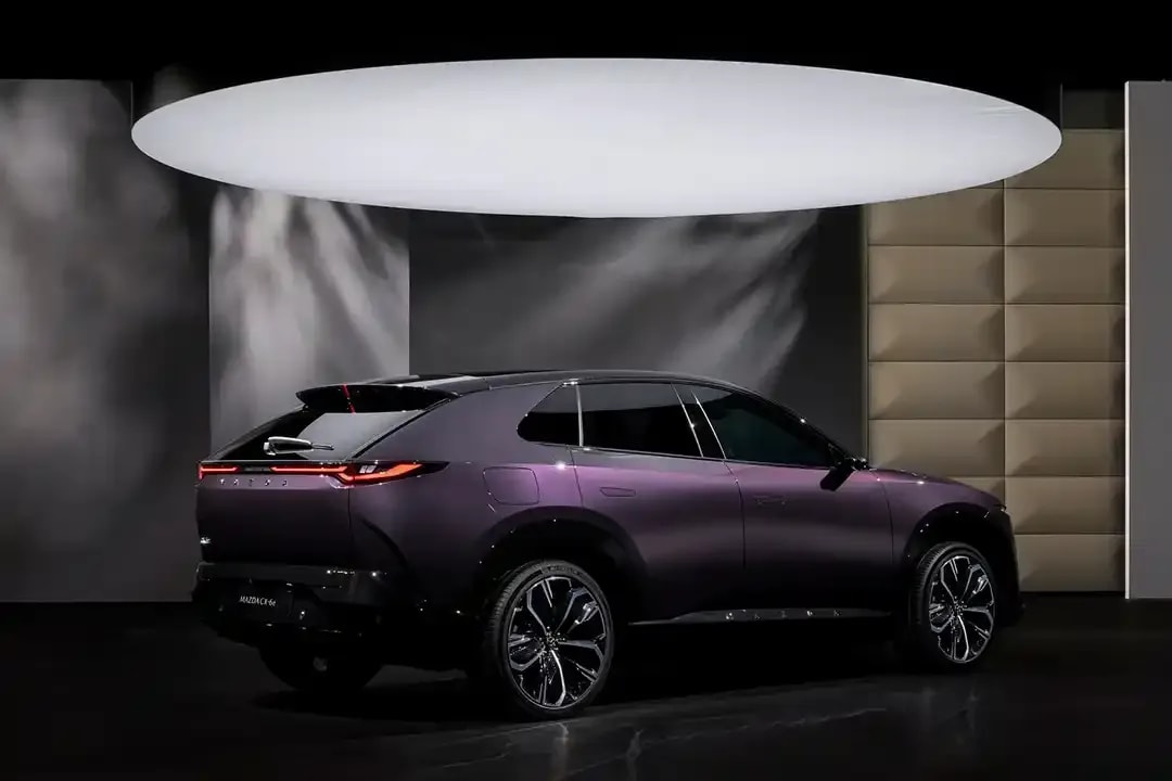 Rear three quarter view of a purple Mazda CX-6e electric SUV on display