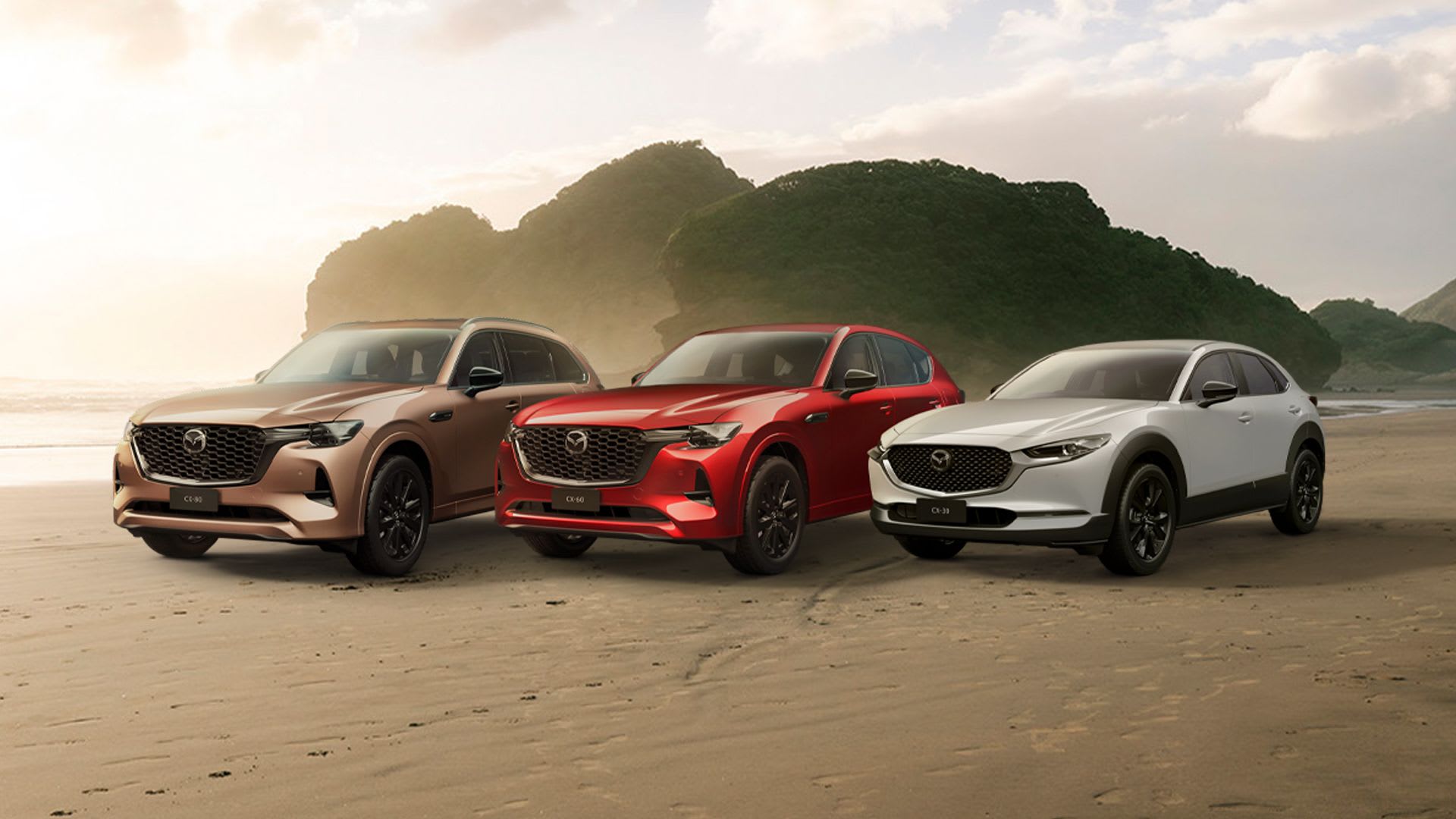 The CX-80, CX-60 and CX-30 SUVs lined up on a New Zealand beach to promote Mazda's red hot sale