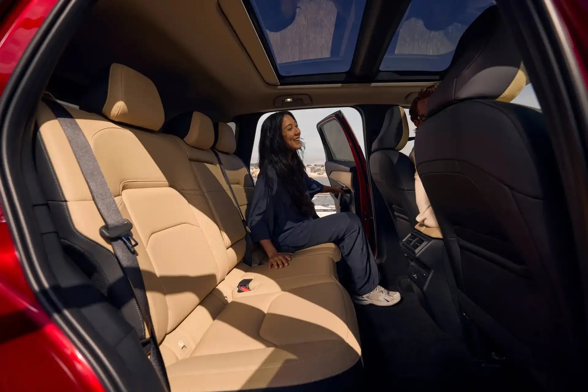 Woman sitting in the back tan leather seat of a Mazda CX-5 SUV