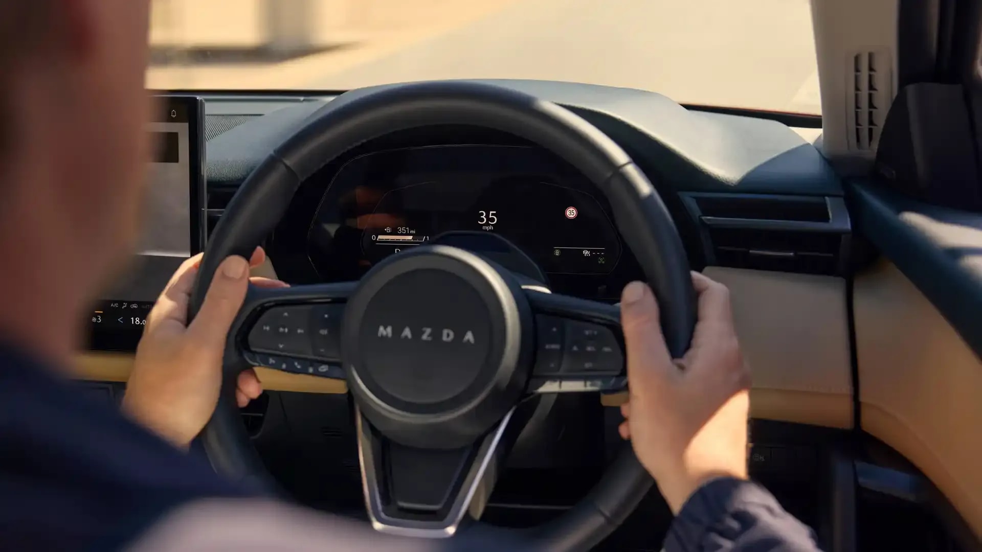 Hands gripping the steering wheel of a Mazda CX-5 SUV