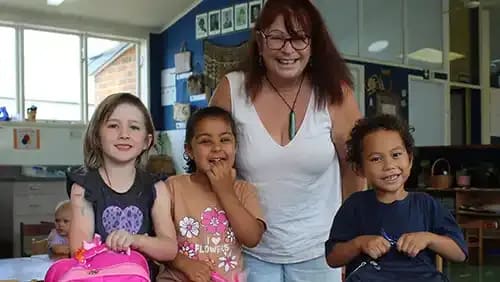 Teacher and three young students in a classroom with School Start First Impressions