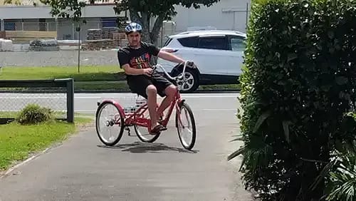 Boy sitting on his tricycle in his driveway