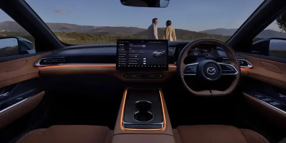 Front view of the all-electric Mazda 6e hatchback's cockpit showing the ambient lighting design