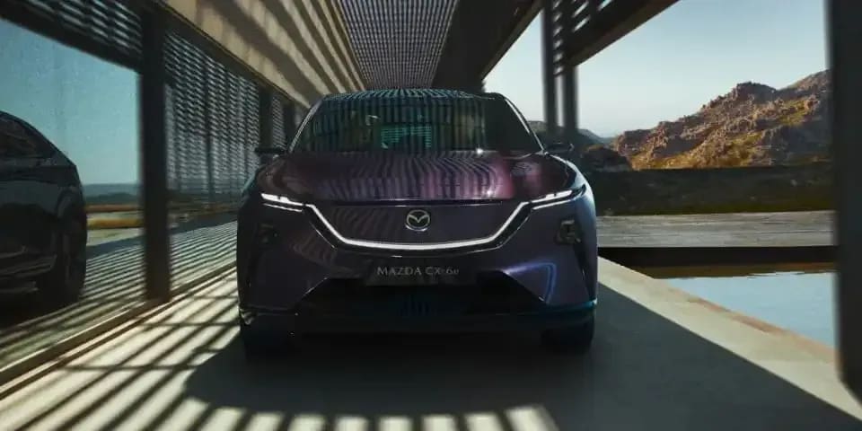 Front view of a Nightfall Violet all-electric Mazda CX-6e SUV with signature front headlights
