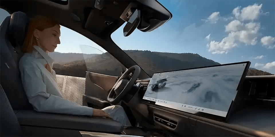 Woman sitting in the driver's seat of the all-electric Mazda CX-6e SUV with it's extra large 26.45" centre touchscreen