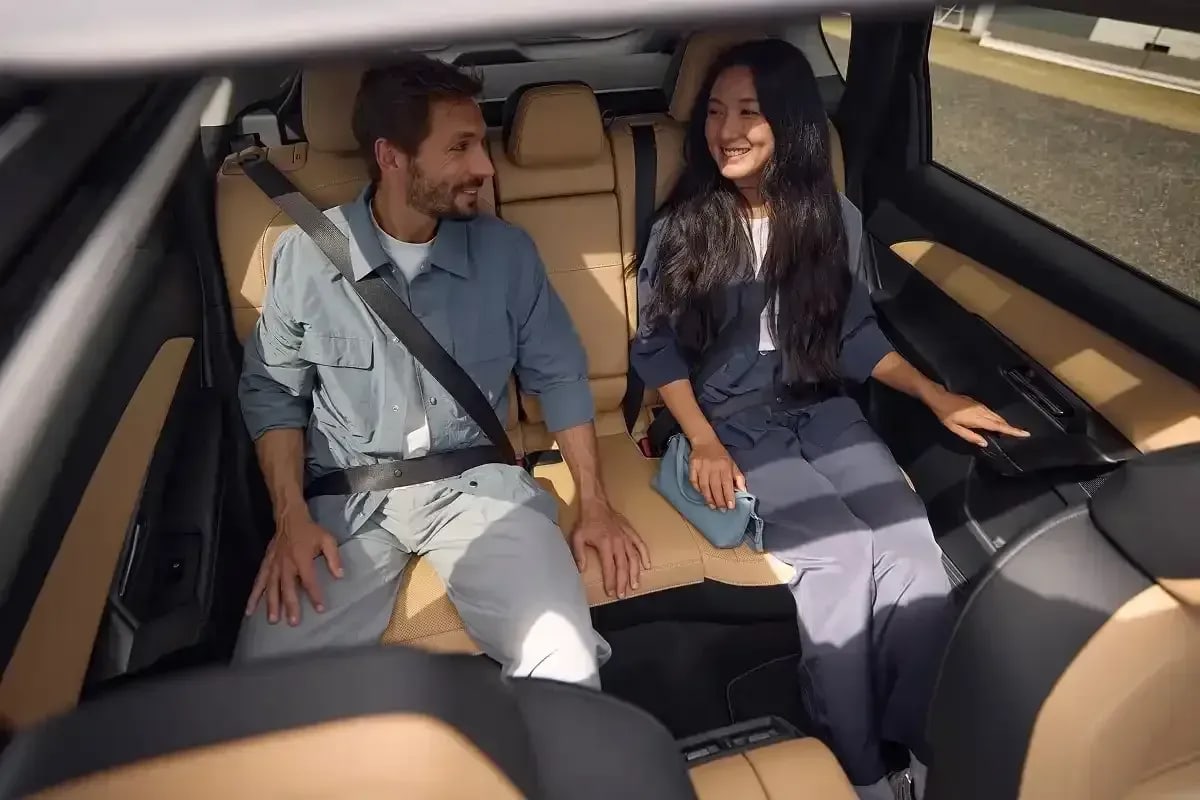 Looking back at a man and woman sitting in the tan leather rear seats of a Mazda CX-5 SUV