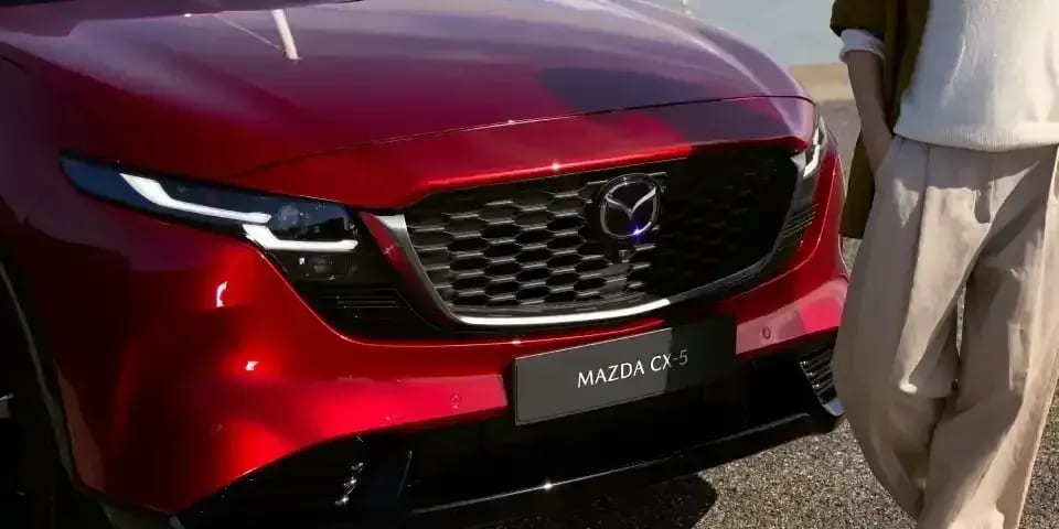 Close up of the front grille of a Soul Red Mazda CX-5 SUV