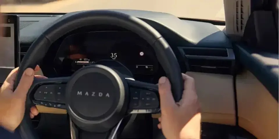 Looking through the steering wheel of a Mazda CX-5 SUV at the digital dashboard display