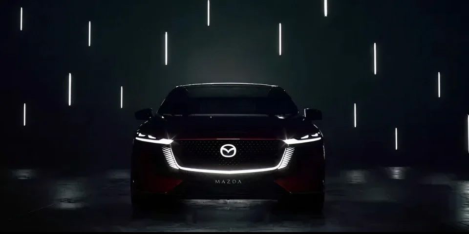 Front silhouette view of the all-electric Mazda 6e showing the signature light design 
