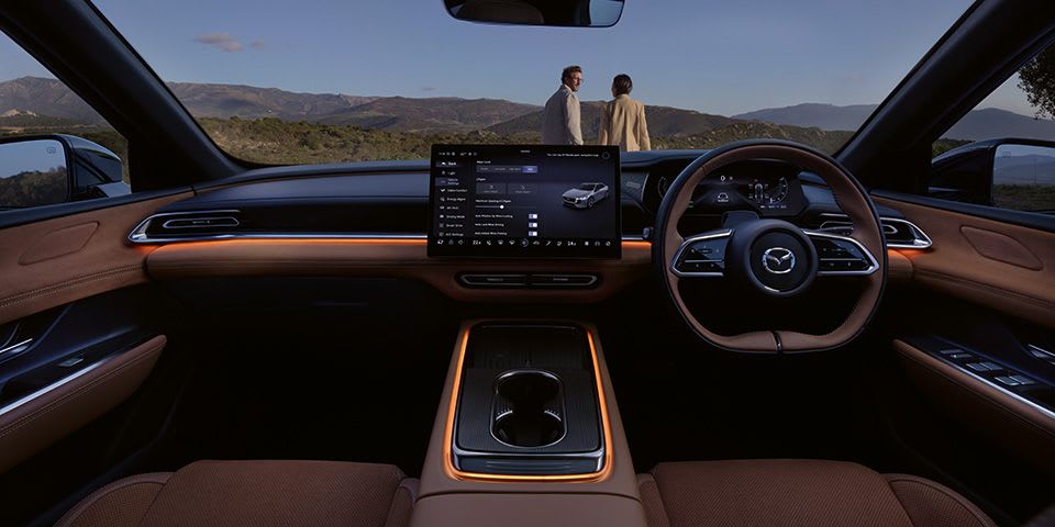 Front view of the all-electric Mazda 6e hatchback's cockpit showing the ambient lighting design